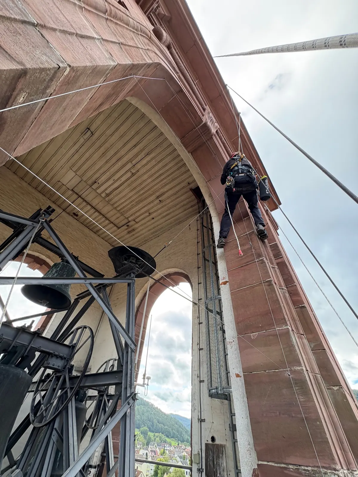 Industriekletterer installiert Netze zur Taubenabwehr an einem Glockenturm